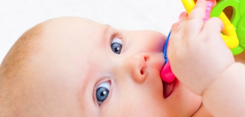 Little baby girl playing with teething toy